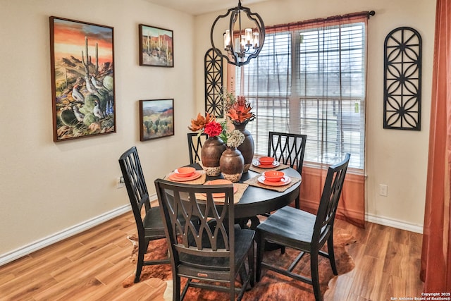 dining space featuring wood-type flooring and a chandelier