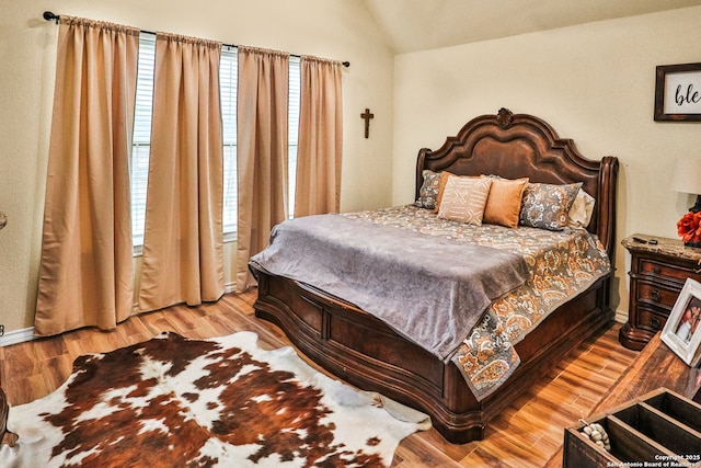 bedroom featuring lofted ceiling and light wood-type flooring