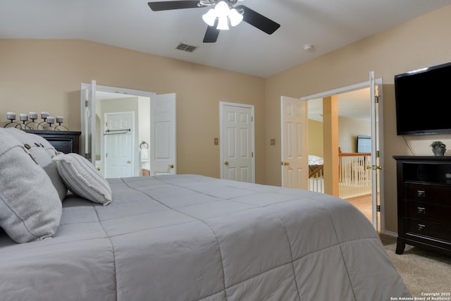 bedroom with lofted ceiling, ensuite bath, light colored carpet, and ceiling fan