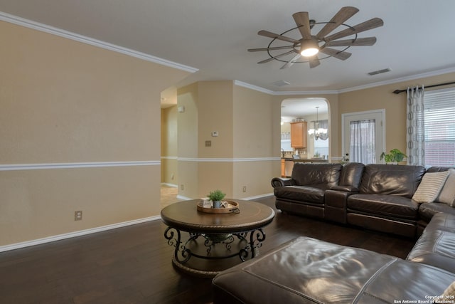 living room featuring ceiling fan with notable chandelier, dark wood-type flooring, and ornamental molding