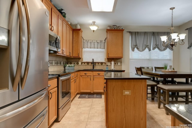 kitchen with sink, an inviting chandelier, a center island, appliances with stainless steel finishes, and backsplash