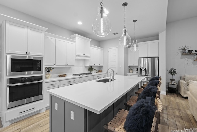 kitchen with white cabinetry, sink, a center island with sink, and appliances with stainless steel finishes