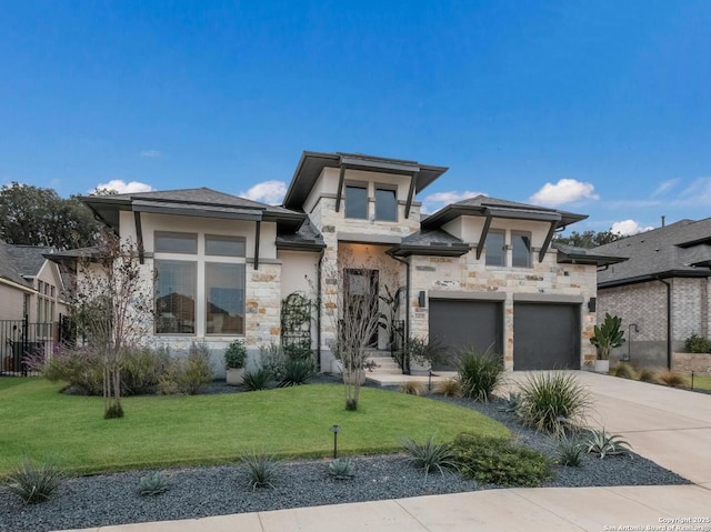 prairie-style home featuring a garage and a front lawn