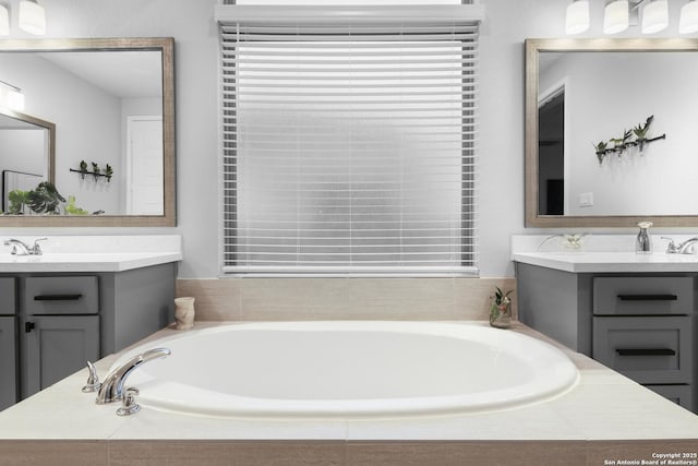 bathroom featuring vanity and a relaxing tiled tub