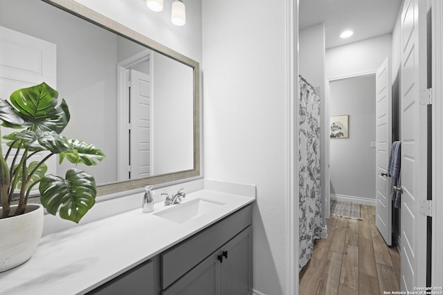 bathroom with hardwood / wood-style flooring, vanity, and walk in shower