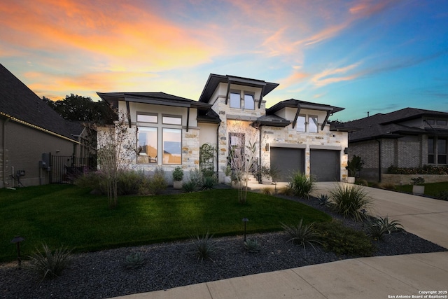 prairie-style home with a garage and a lawn