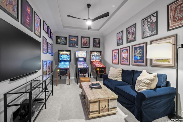 carpeted living room featuring ceiling fan and a raised ceiling