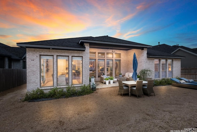 back house at dusk with a patio area