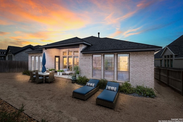 back house at dusk with a patio