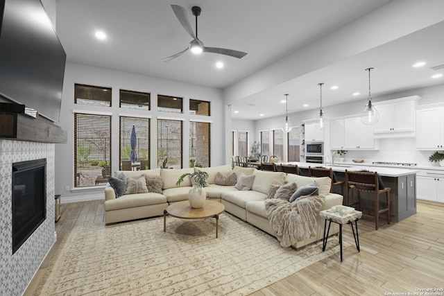 living room with ceiling fan, sink, and light hardwood / wood-style floors