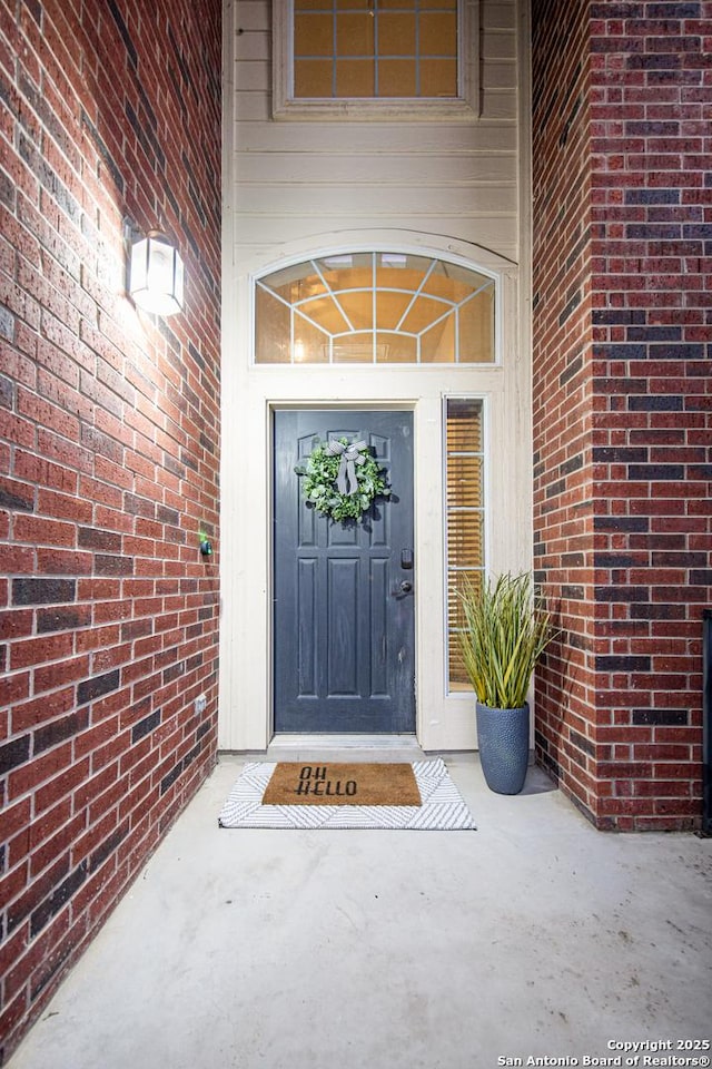 property entrance featuring brick siding