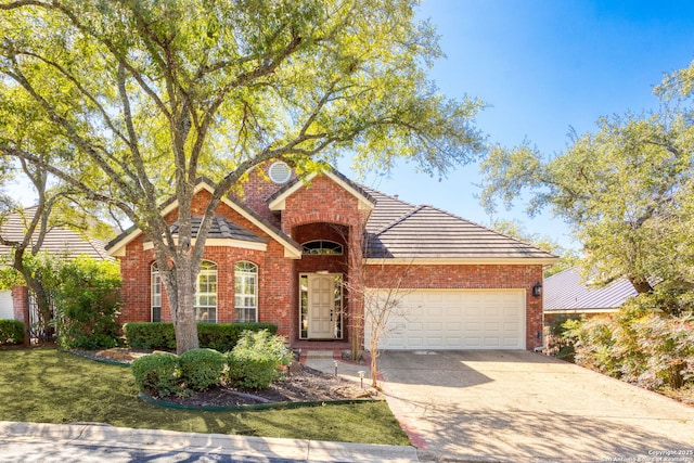 view of front of property featuring an attached garage, brick siding, driveway, a tiled roof, and a front lawn