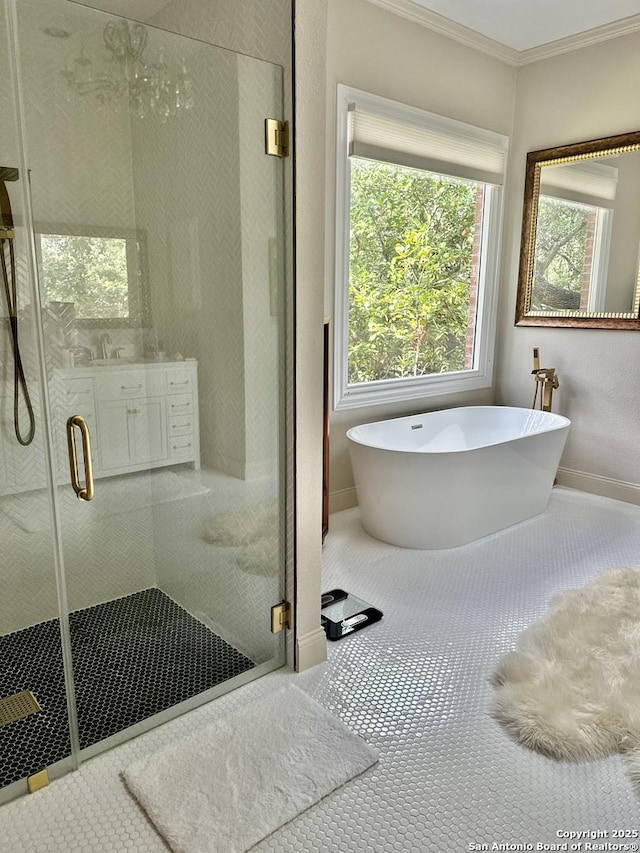 bathroom featuring a freestanding tub, crown molding, a shower stall, and baseboards