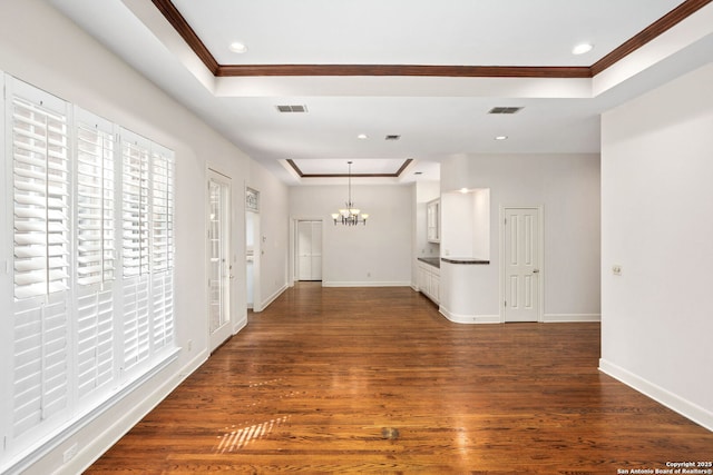 hall featuring visible vents, baseboards, dark wood-style floors, a tray ceiling, and crown molding