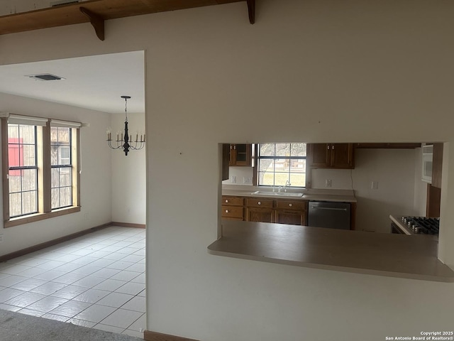 kitchen with hanging light fixtures, plenty of natural light, dishwasher, and light tile patterned flooring