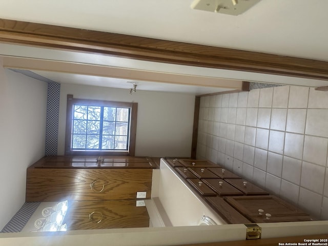 interior space with tasteful backsplash and beamed ceiling