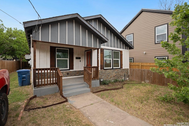 view of front of house featuring fence, a porch, and board and batten siding