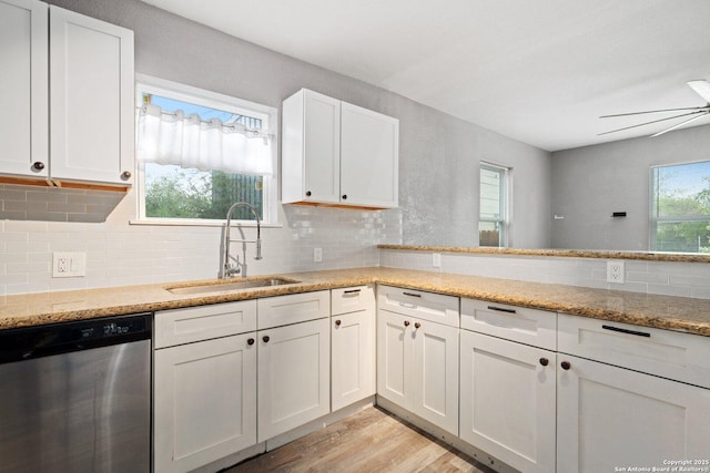 kitchen with white cabinets, dishwasher, a sink, and light wood-style floors