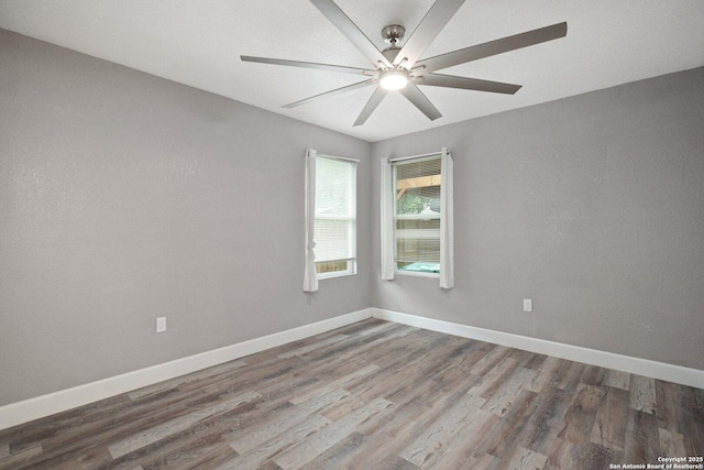 empty room featuring baseboards, wood finished floors, and ceiling fan