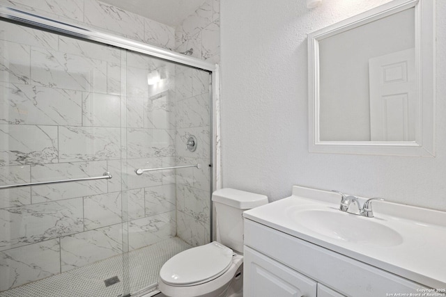 full bathroom featuring vanity, a shower stall, and toilet