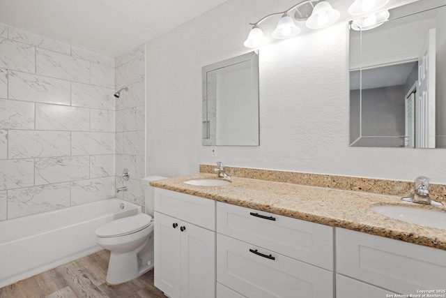 full bath with toilet, wood finished floors, a sink, and shower / tub combination