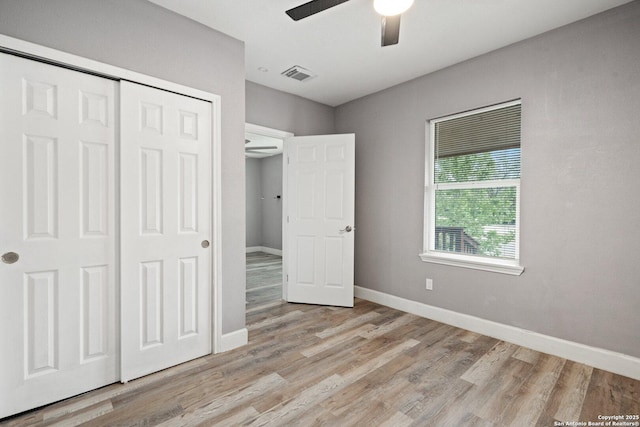 unfurnished bedroom with baseboards, a closet, visible vents, and light wood-type flooring