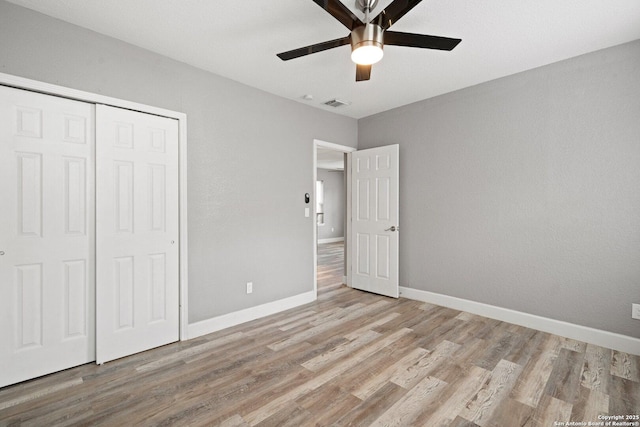 unfurnished bedroom featuring ceiling fan, baseboards, a closet, and light wood-type flooring