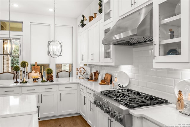 kitchen with white cabinetry, stainless steel gas stovetop, decorative light fixtures, and tasteful backsplash