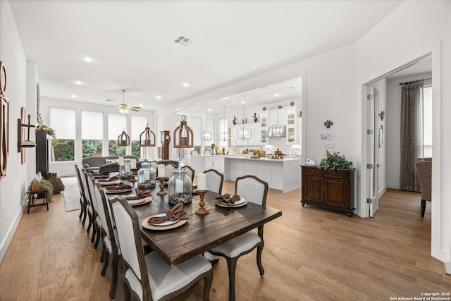 dining space with ceiling fan and light hardwood / wood-style flooring