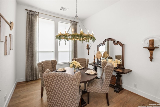 dining room featuring plenty of natural light, hardwood / wood-style floors, and a notable chandelier