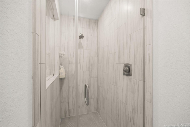 bathroom with a shower with door