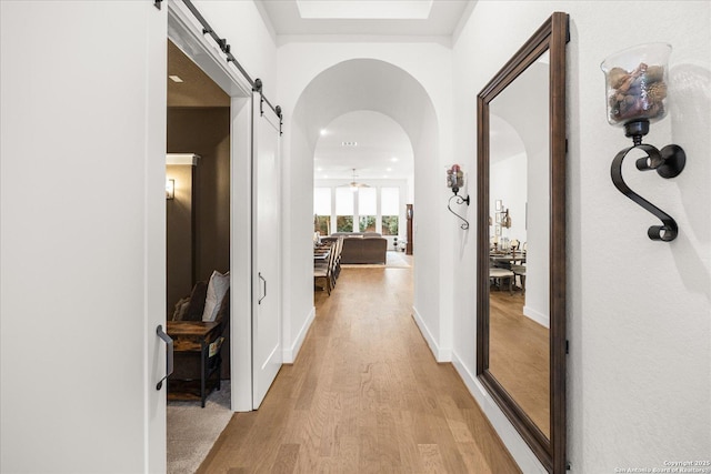 corridor featuring light hardwood / wood-style flooring and a barn door