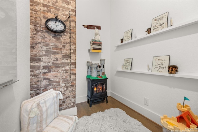 living area featuring hardwood / wood-style flooring and a wood stove