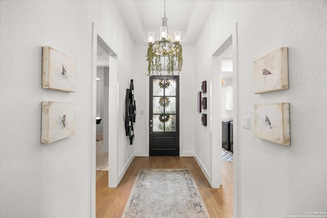 foyer with a chandelier and light wood-type flooring