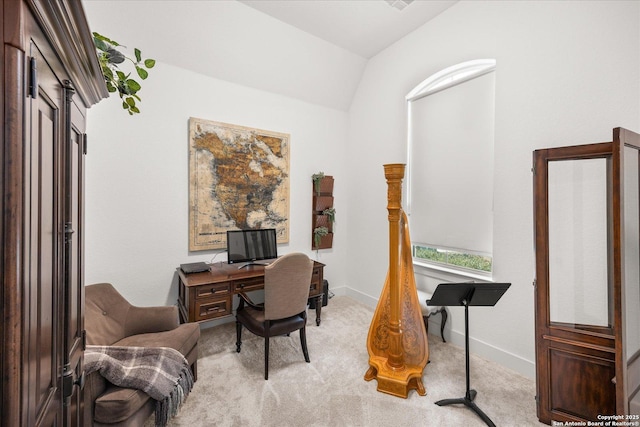 carpeted home office with vaulted ceiling