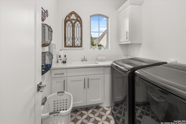 laundry room featuring cabinets, washer and clothes dryer, and sink