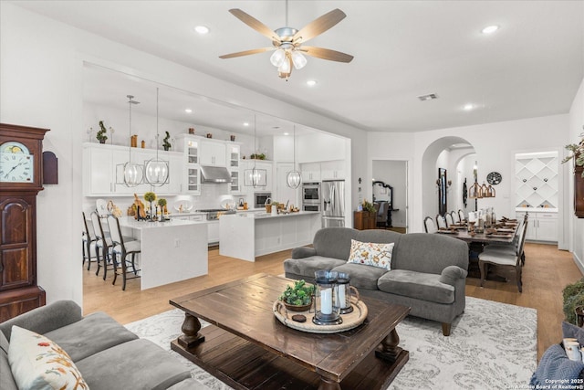 living room with ceiling fan and light wood-type flooring