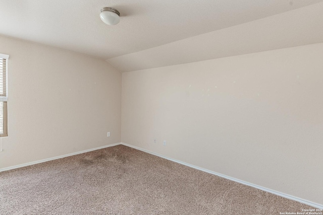 empty room featuring lofted ceiling, a textured ceiling, and carpet