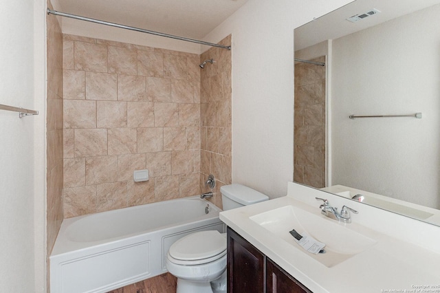 full bathroom with vanity, tiled shower / bath combo, and toilet