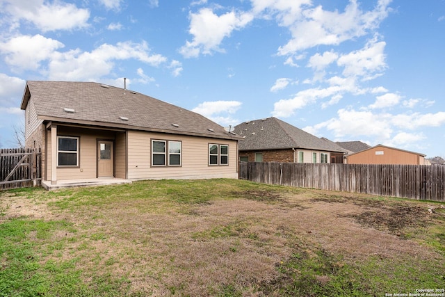 rear view of property featuring a yard and a patio area