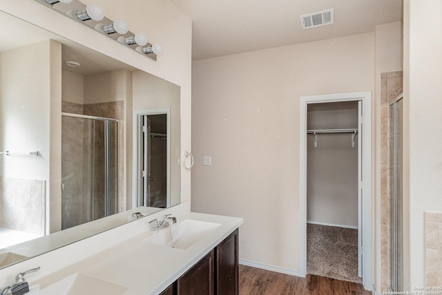 bathroom featuring wood-type flooring, an enclosed shower, and vanity