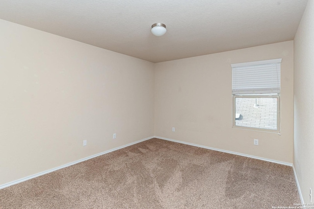 carpeted empty room featuring a textured ceiling