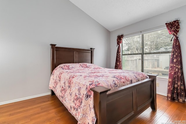 bedroom with lofted ceiling and hardwood / wood-style floors