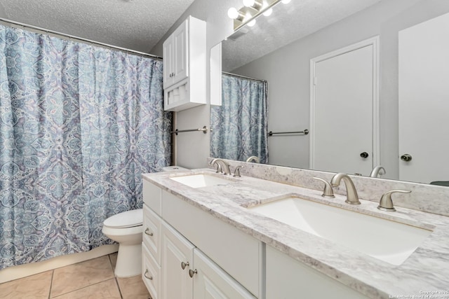 bathroom featuring vanity, tile patterned floors, toilet, and a textured ceiling