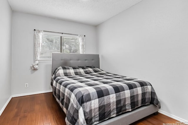 bedroom featuring dark wood-type flooring and a textured ceiling