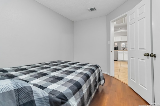 bedroom featuring hardwood / wood-style floors and a textured ceiling