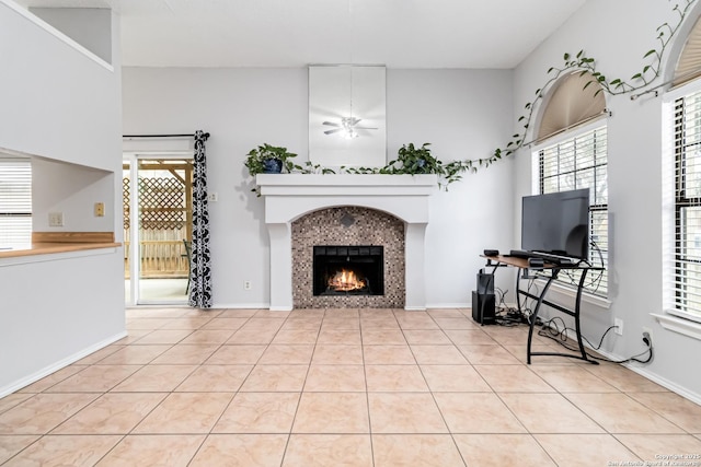 tiled living room with ceiling fan and a fireplace