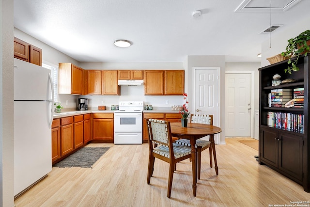 kitchen featuring light wood-type flooring and white appliances