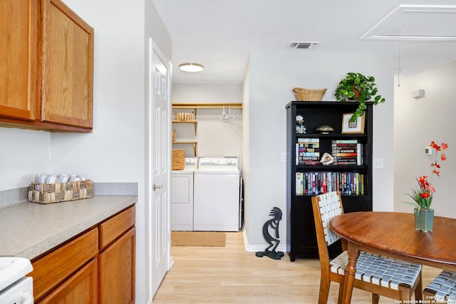 kitchen featuring washing machine and dryer and light hardwood / wood-style flooring