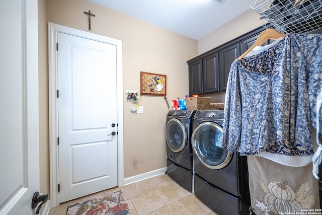 clothes washing area with cabinets and washing machine and clothes dryer